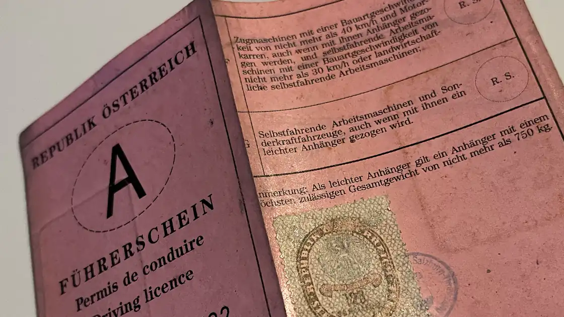 Im Symbolfoto ein typischer alter Führerschein, der noch vor den Scheckkarten-Format-Führerscheinen in Österreich ausgegeben wurde. Genannt wird er auch der »Rose Fetzen« weil es sich um ein rosarotes Stück Papier mit 2 Faltungen handelt.