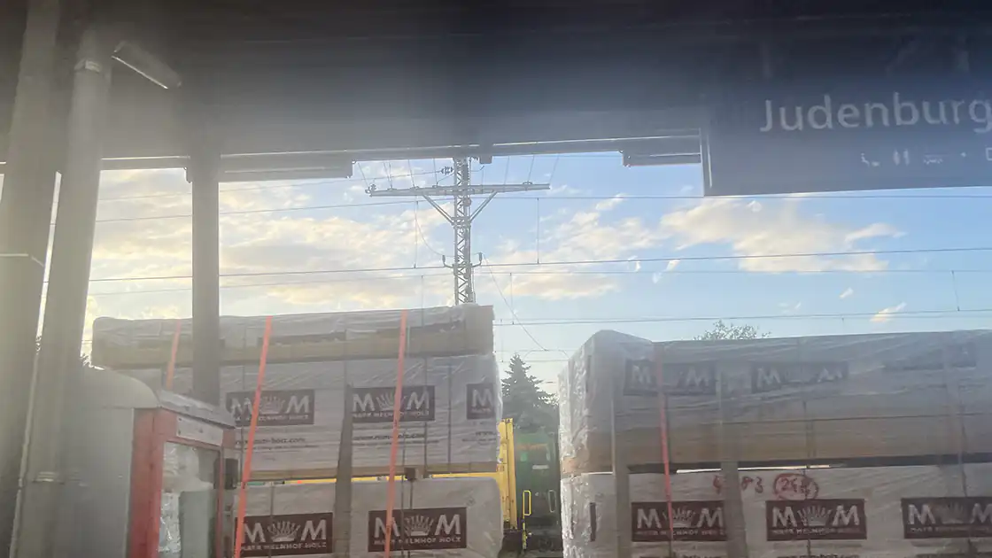 Auf dem Bild zu sehen ein Bahnsteig am Bahnhof Judenburg auf dem sich rechts im Bild ein Lebensmittel- und Getränkeautomat befindet, auf dem gegenüberliegenden Bahnsteig befindet sich im Bild ein Güterzug.