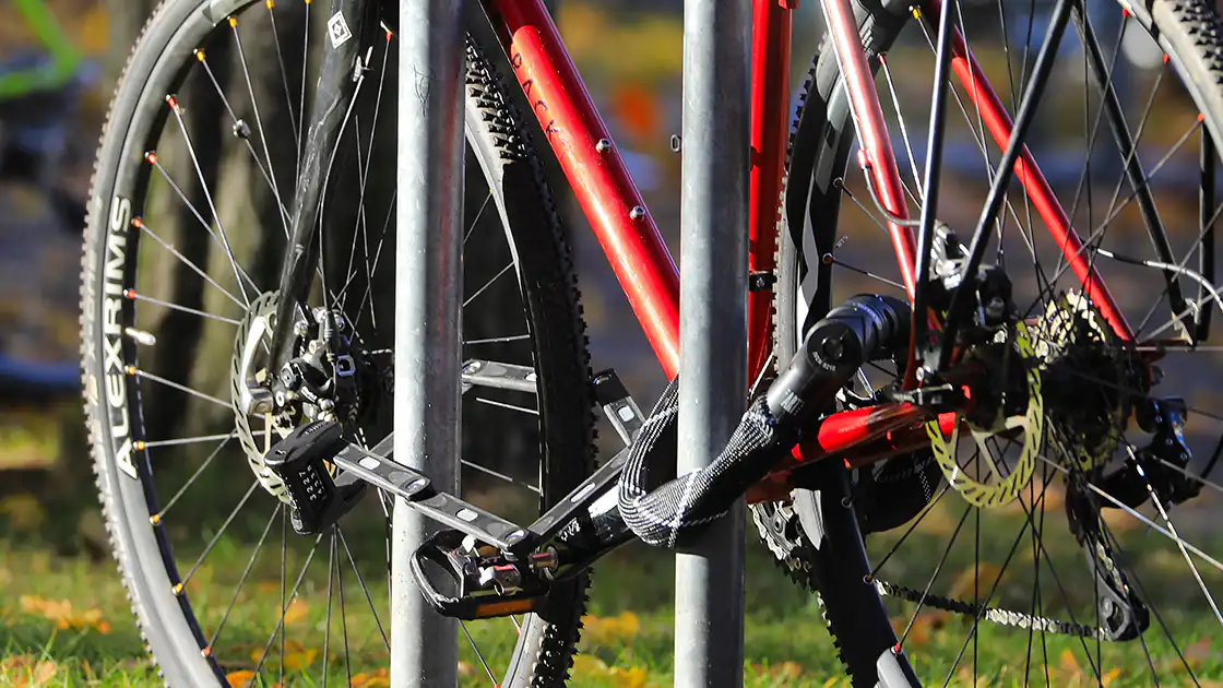 Im Bild zu sehen eine Detailaufnahme von einem Fahrrad, das mit mehreren Schlössern gesichert ist.