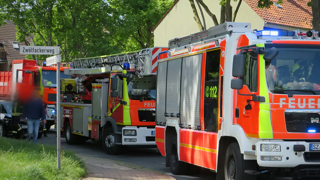 Mehrere Feuerwehrfahrzeuge und Rettungsdienst bei einem größeren Einsatz auf einer Straße. Das zweite Fahrzeug im Bild hat auch eine Drehleiter.