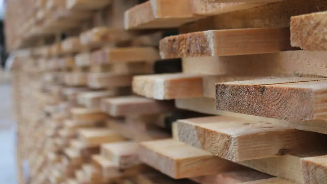 Ein großer Stapel mit Holzbrettern in einem Sägewerk oder einer Tischlerei ist in diesem Bild zu sehen.
