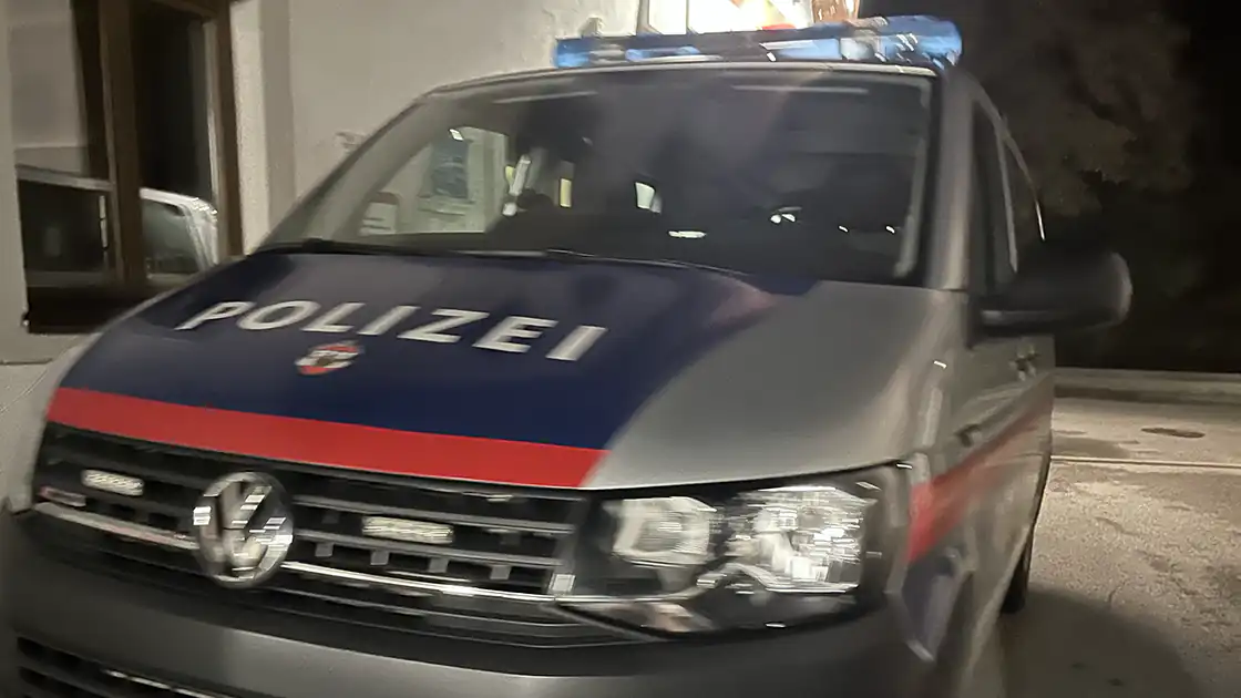 Vor einer Polizeistation in einer Landgemeinde ist ein Polizeiwagen zu sehen. Er steht auf der Straße vor der Polizeiwache.
