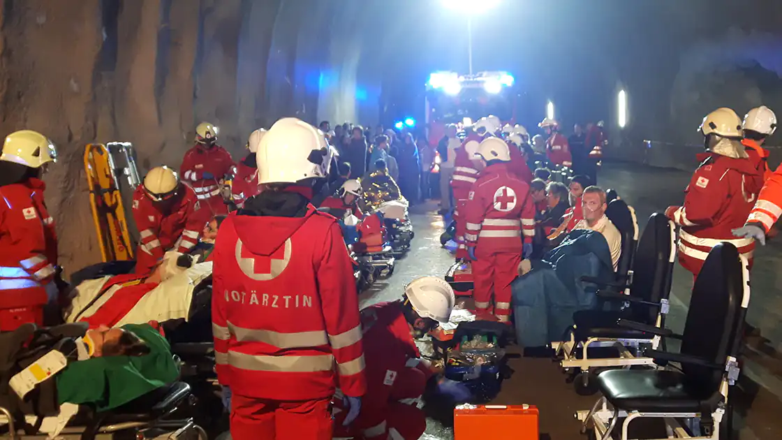 Großeinsatz der Rettung - Rotes Kreuz und Feuerwehr - ist hier das Thema auf der Seite. In unserem Symbolphoto ist ein solcher Großeinsatz mit zahlreichen verletzten Personen sowie zahlreichen Einsatzfahrzeugen der Rettung zu sehen.