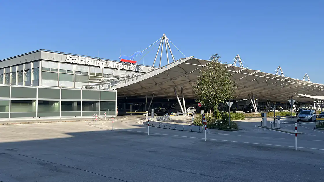 Auf dem Symbolbild hier ist das Flughafen-Hauptgebäude vom Salzburg Airport Wolfgang Amadeus Mozart zu sehen. Darin sind die Terminals 1 und 2 untergebracht, im Gebäude befindet sich unten der Check-In-Bereich und es gibt auf der gegenüberliegenden Seite eine schöne Dachterrasse, die den Blick auf das Flugfeld bietet. Der Flughafen in Salzburg ist ein Regionalflughafen mit internationalen Verbindungen.