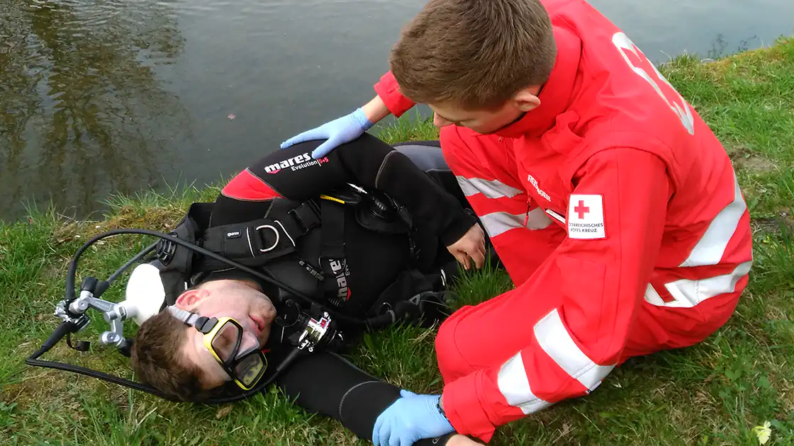 Bei einem Rettungseinsatz neben einem Bach oder einem Fluß - im Bild zu sehen ist ein Taucher, der offenbar von einem Sanitäter am Ufer eines Flusses behandelt wird - kämpfen die Rettungskräfte auch oft um das Überleben des Patienten.