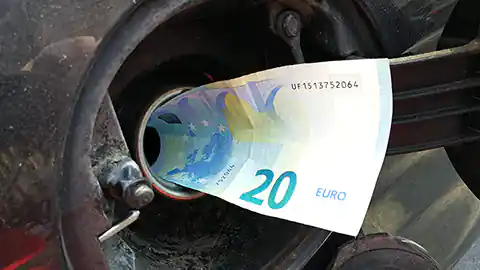 Symbolbild für die Kosten beim Tanken für Autos. Das Bild zeigt eine Tanköffnung eines Autos und statt einem Benzinschlauch steckt darin ein 20-Euro-Schein.