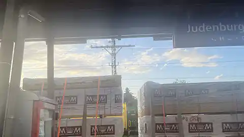 Auf dem Bild zu sehen ein Bahnsteig am Bahnhof Judenburg auf dem sich rechts im Bild ein Lebensmittel- und Getränkeautomat befindet, auf dem gegenüberliegenden Bahnsteig befindet sich im Bild ein Güterzug.