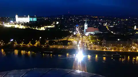 Blick über die Stadt Bratislava (Slowakei) in der Nacht. Viele Lichter sind zu sehen, unter anderem sieht man im Bild auch links die beleuchtete Burg von Bratislava.
